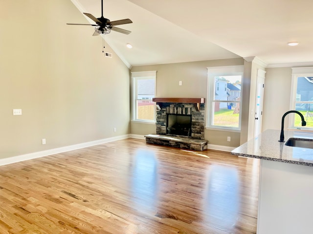 unfurnished living room featuring a wealth of natural light, sink, and light hardwood / wood-style flooring