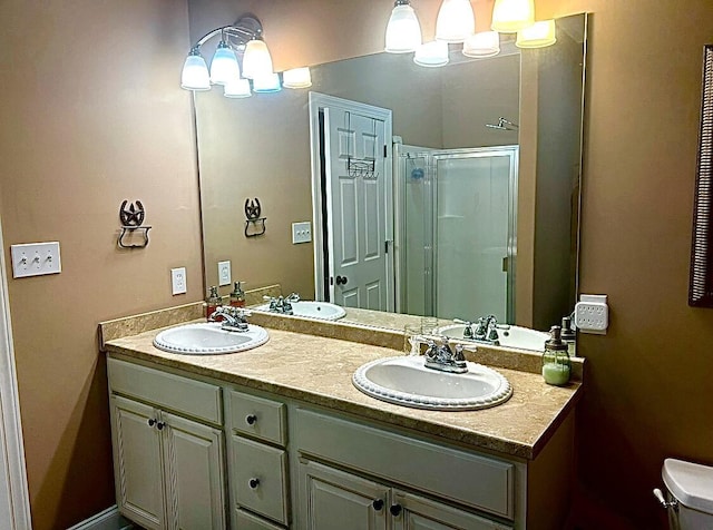 bathroom featuring vanity, toilet, and a shower with door