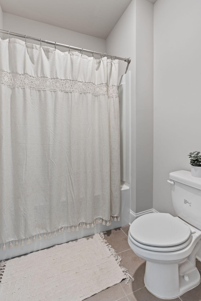 bathroom with toilet, tile patterned floors, and shower / tub combo with curtain