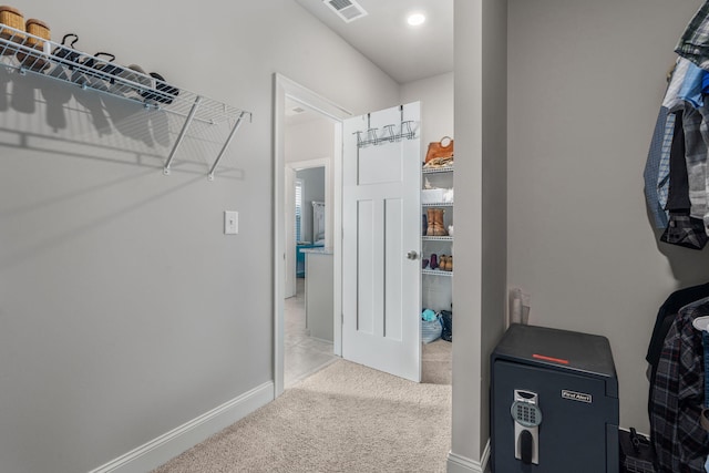 walk in closet featuring light colored carpet