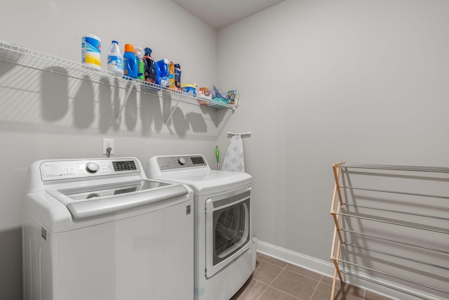 laundry room with washer and clothes dryer and dark tile patterned floors