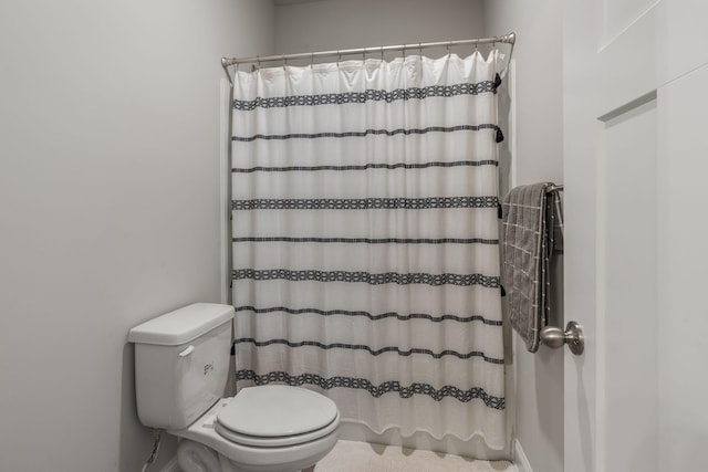 bathroom featuring a shower with shower curtain and toilet