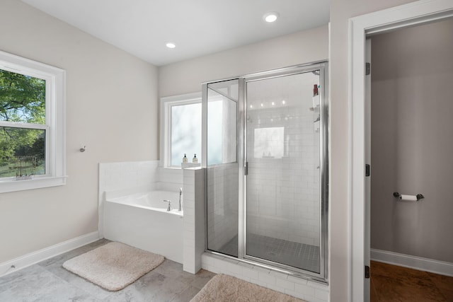 bathroom with tile patterned flooring, plus walk in shower, and a wealth of natural light