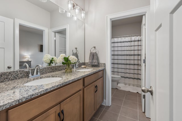 bathroom featuring tile patterned flooring, vanity, toilet, and walk in shower