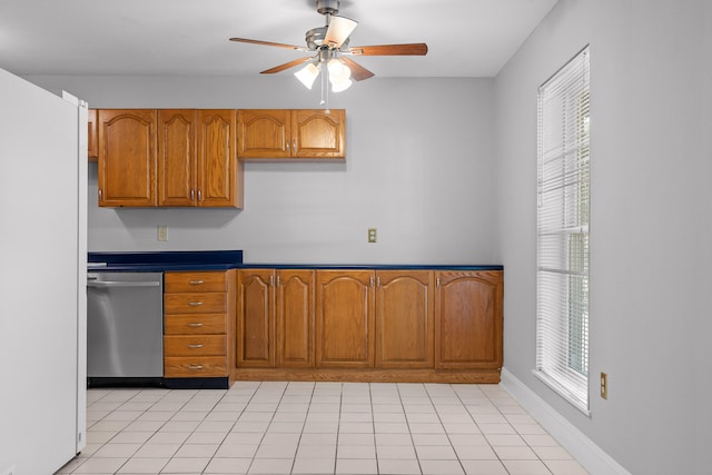 kitchen with stainless steel dishwasher, a healthy amount of sunlight, and light tile patterned floors