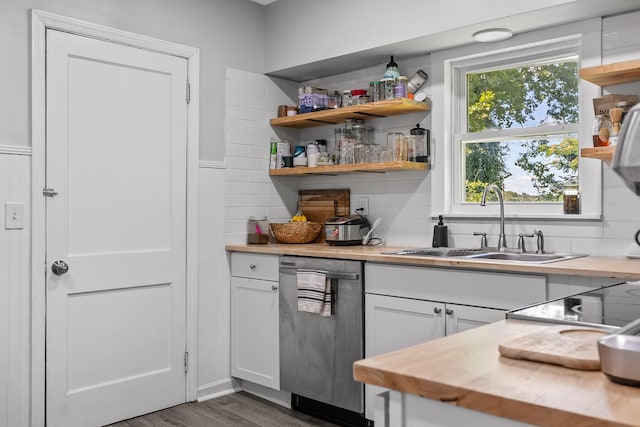 kitchen with sink, stainless steel dishwasher, dark hardwood / wood-style floors, decorative backsplash, and white cabinetry