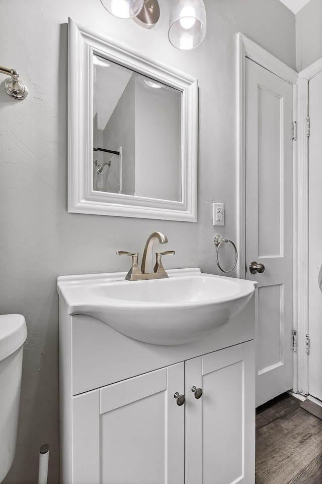 bathroom featuring vanity, toilet, and wood-type flooring