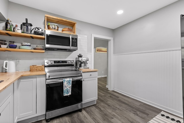 kitchen featuring wooden counters, appliances with stainless steel finishes, dark hardwood / wood-style floors, and white cabinetry