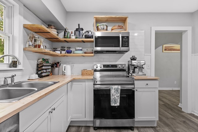 kitchen with a healthy amount of sunlight, white cabinetry, and appliances with stainless steel finishes