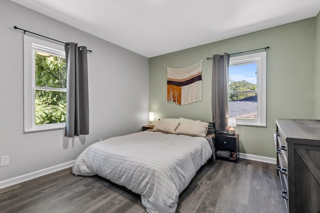 bedroom with dark hardwood / wood-style flooring and multiple windows