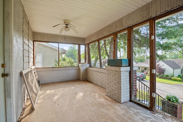 unfurnished sunroom featuring a ceiling fan and a healthy amount of sunlight