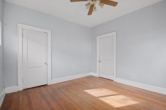 spare room with baseboards, a ceiling fan, and wood finished floors