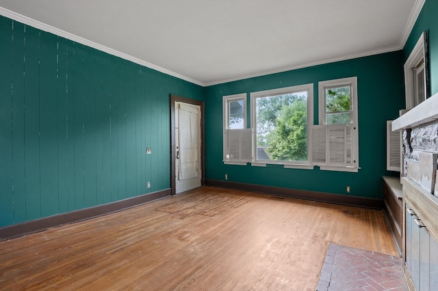 unfurnished room with baseboards, crown molding, and wood finished floors