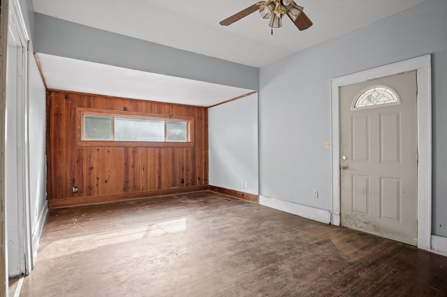 foyer entrance featuring plenty of natural light, wooden walls, wood finished floors, and a ceiling fan