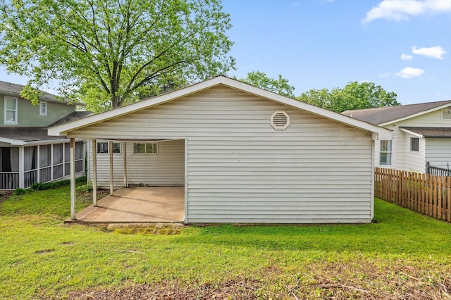 rear view of house featuring fence, a patio, a sunroom, and a lawn