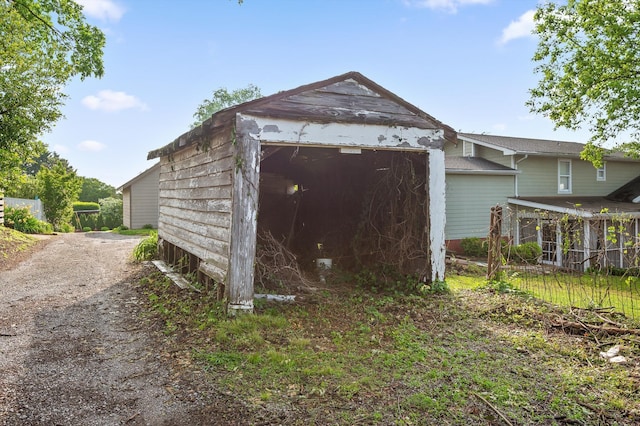 garage featuring driveway and a storage shed
