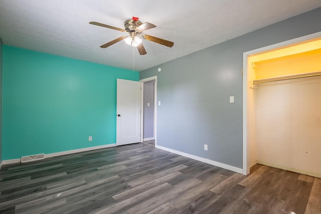 unfurnished bedroom with a closet, wood finished floors, baseboards, and ceiling fan