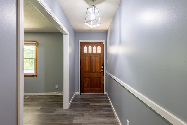 entrance foyer featuring baseboards and dark wood finished floors