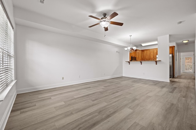 7510 Noah Reid Rd, Chattanooga, TN 37416 - unfurnished living room featuring a chandelier, ceiling fan, light wood-type flooring, and baseboards
