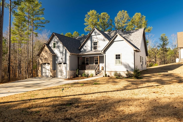 view of front of property with a garage, concrete driveway, and a porch