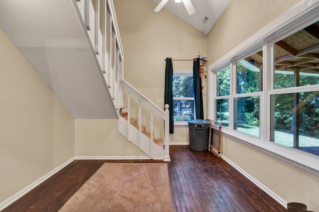 stairway featuring ceiling fan, wood-type flooring, and high vaulted ceiling