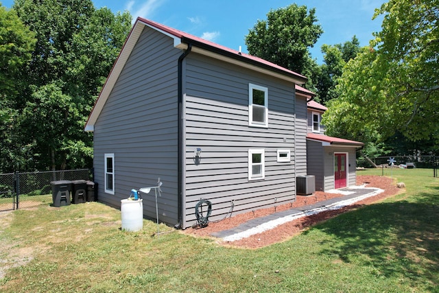 view of side of home featuring a yard and cooling unit