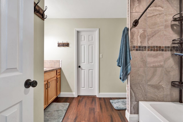 bathroom featuring hardwood / wood-style floors, vanity, and tiled shower / bath