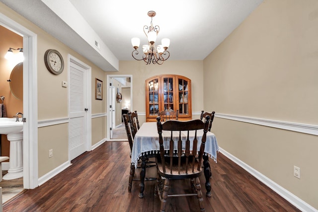 dining space featuring dark hardwood / wood-style flooring and an inviting chandelier