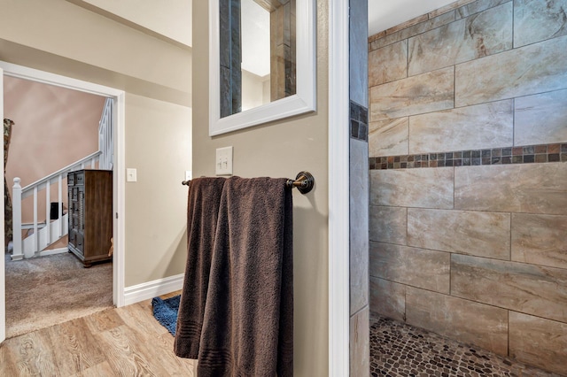 bathroom with hardwood / wood-style floors and tiled shower