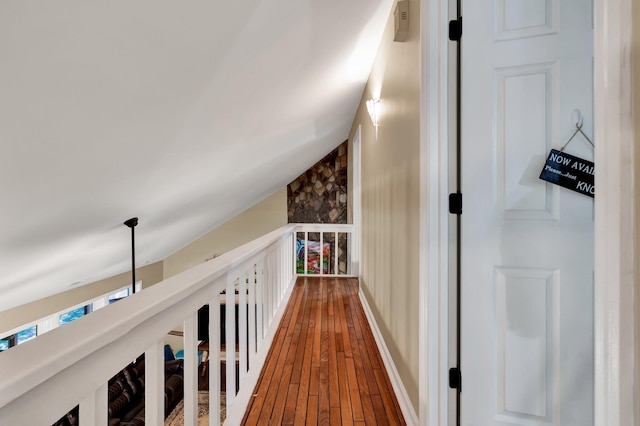 hallway with dark hardwood / wood-style floors and vaulted ceiling