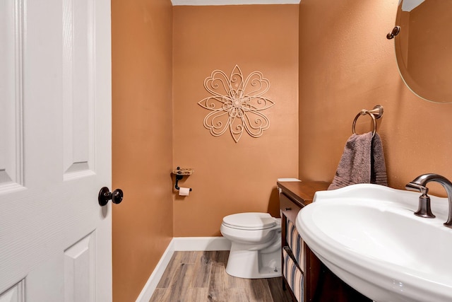 bathroom featuring hardwood / wood-style floors, toilet, and sink