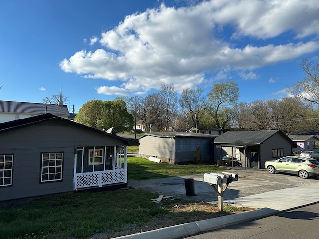 view of side of property featuring a residential view, a lawn, and driveway