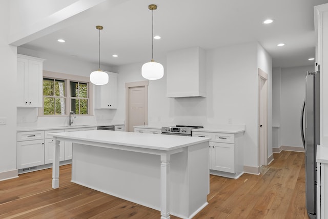 kitchen featuring white cabinetry, a center island, sink, light hardwood / wood-style floors, and custom range hood