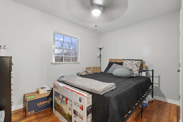 bedroom featuring wood finished floors, baseboards, and a ceiling fan