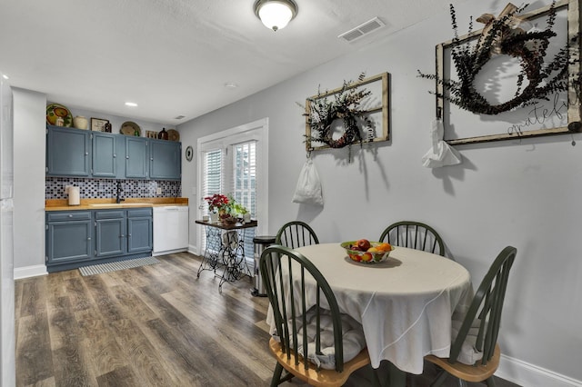 dining space with dark hardwood / wood-style flooring and sink