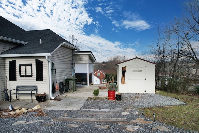 view of side of home featuring a patio and a storage shed