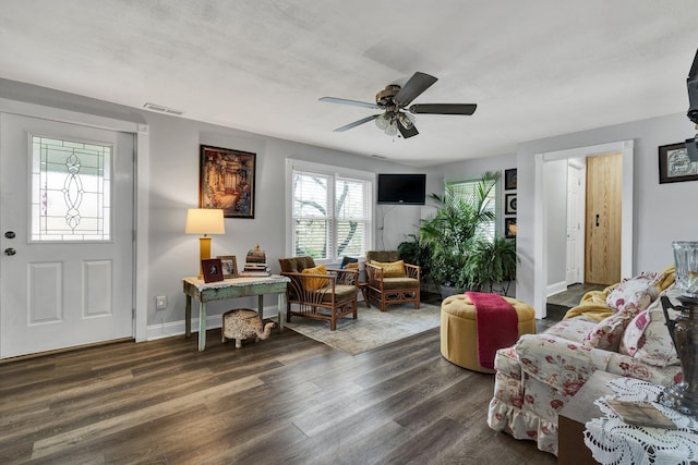 living room with ceiling fan and dark wood-type flooring