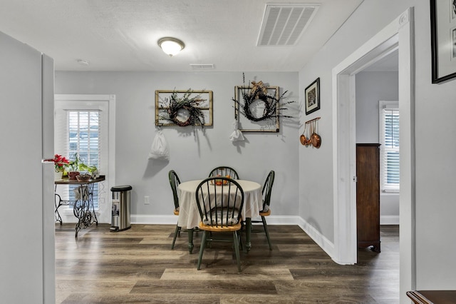 dining room with dark hardwood / wood-style flooring and a textured ceiling