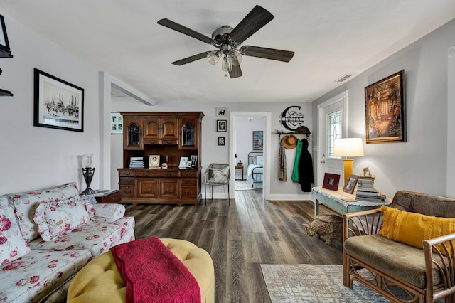 living room with ceiling fan and dark wood-type flooring