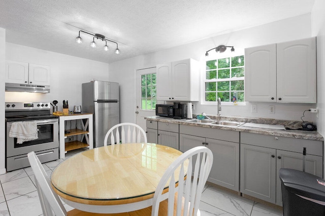 kitchen with gray cabinets, sink, stainless steel appliances, and a textured ceiling