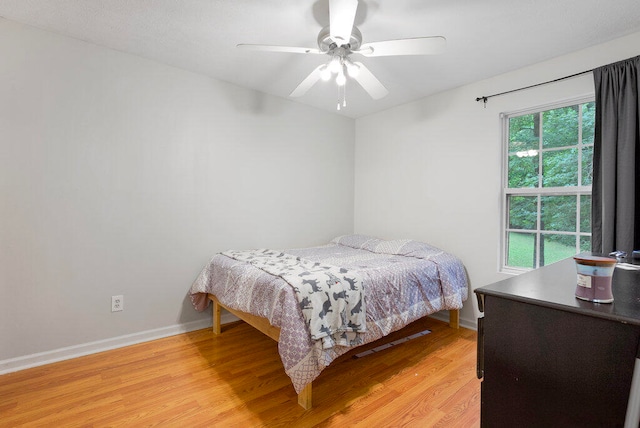 bedroom with ceiling fan and light hardwood / wood-style floors