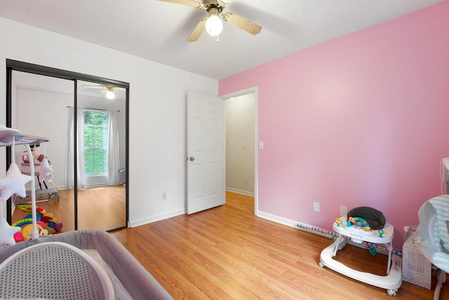 recreation room with light hardwood / wood-style floors and ceiling fan