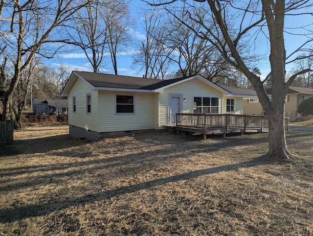 view of front of property with a wooden deck and a front lawn