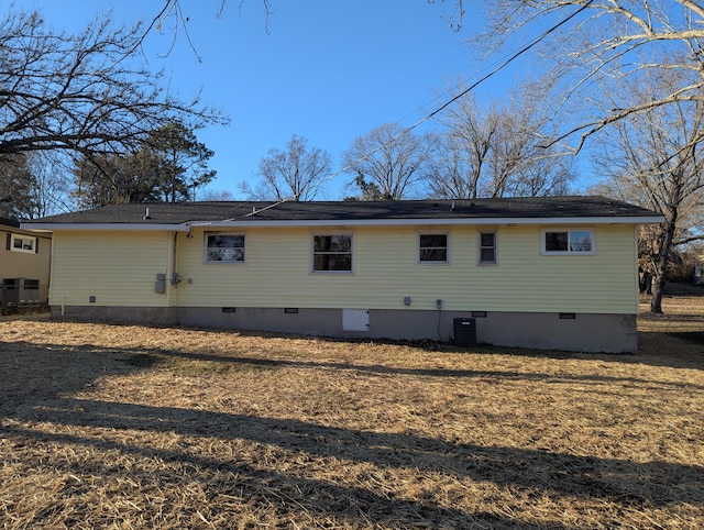 rear view of property featuring central AC and a lawn