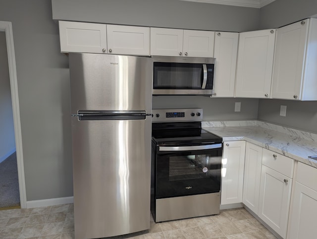 kitchen featuring white cabinetry, appliances with stainless steel finishes, crown molding, and light stone counters