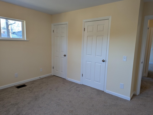 unfurnished bedroom with light colored carpet