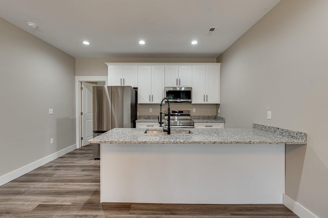 kitchen featuring light stone countertops, white cabinetry, appliances with stainless steel finishes, and sink