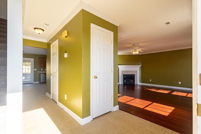 corridor featuring crown molding and light tile patterned flooring