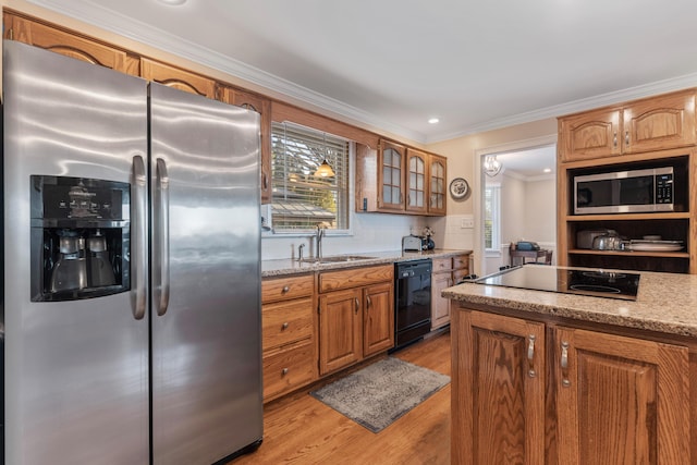 kitchen with plenty of natural light, light stone countertops, sink, and black appliances