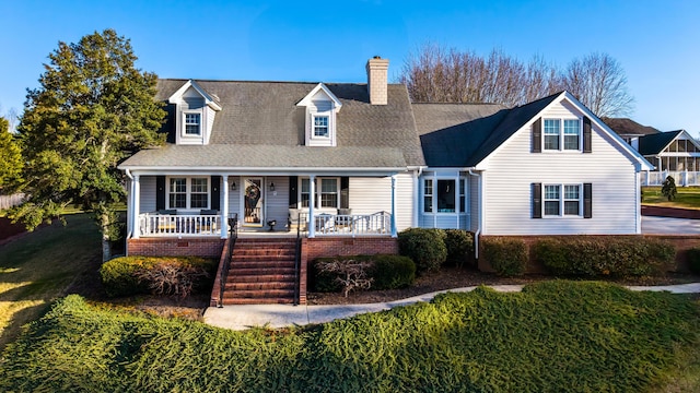 cape cod-style house featuring a porch and a front yard